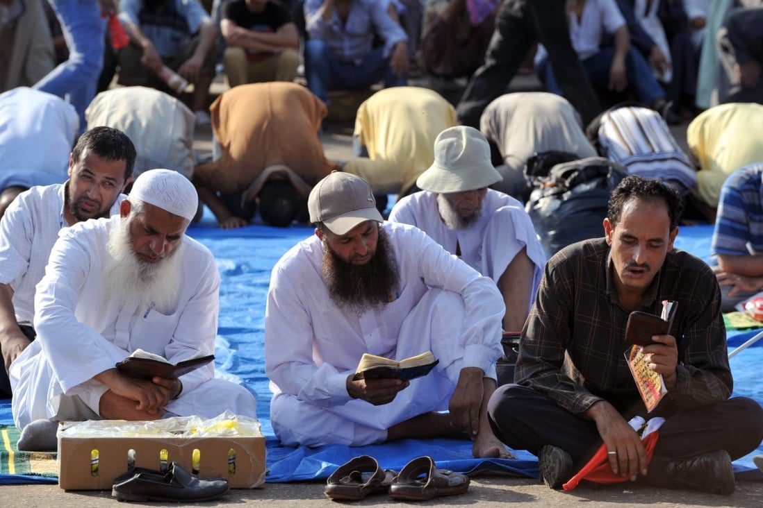 Egyptian supporters of deposed president Mohamed Morsi read the Koran, Islam's holy book, and pray, as they continue to hold a sit in outside Cairo's Rabaa al-Adawiya mosque. Egypt was braced for more bloodshed on Friday. Photo: AFP