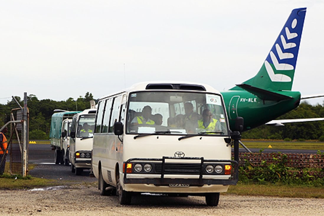 The first group of 40 asylum-seekers arrive in mini-buses shortly after landing on Manus Island, Papua New Guinea, formally bringing into effect the Regional Settlement Arrangement on Thursday. Photo: AFP