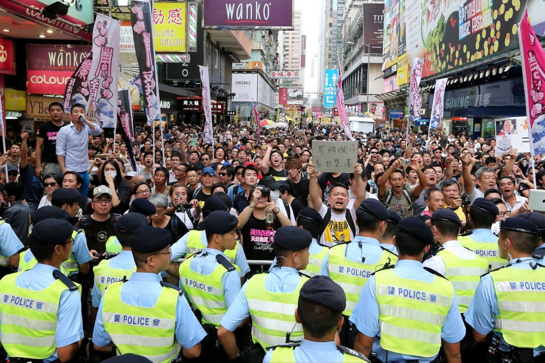 Police block supporters of primary school teacher Alpais Lam as hundreds of people staged a rally in support of police in Mong Kok yesterday. Photo: Felix Wong