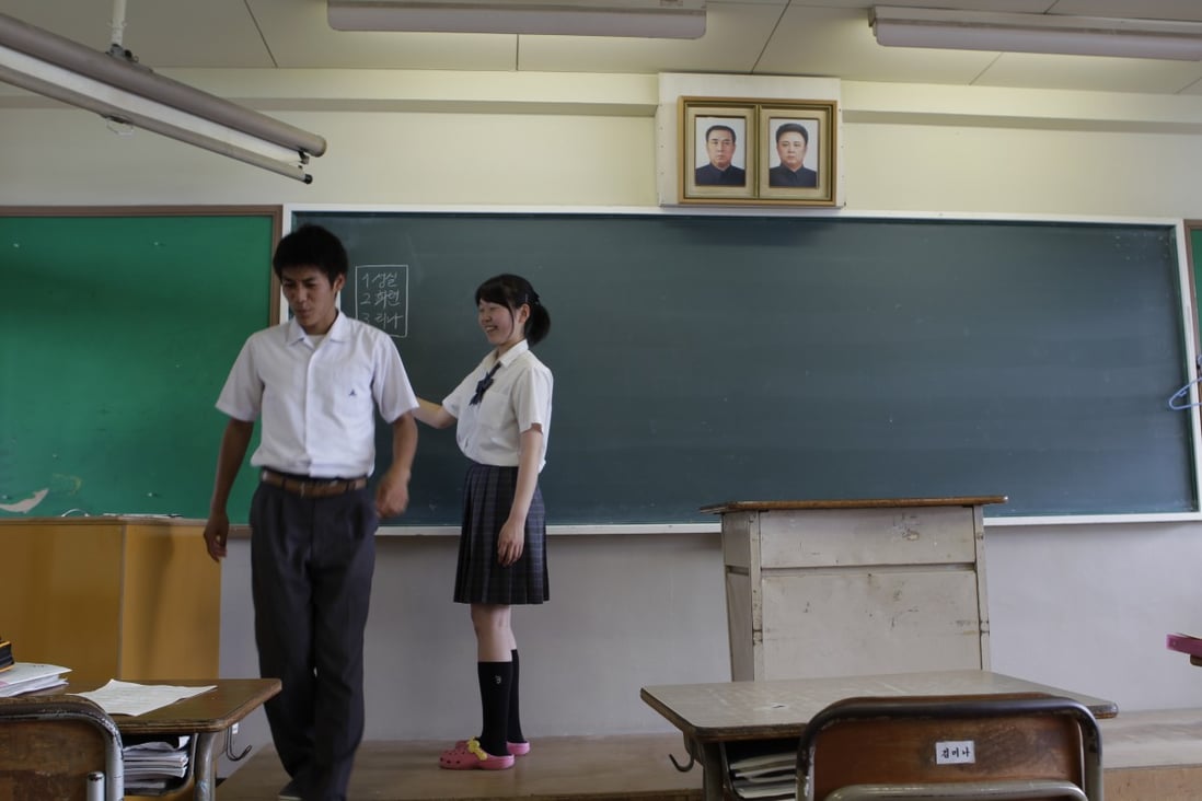High school students stand in a classroom with portraits of the late North Korean leaders, Kim Il Sung, left, and Kim Jong Il, at a North Korean school in Toyohashi,Japan. Photo: AP