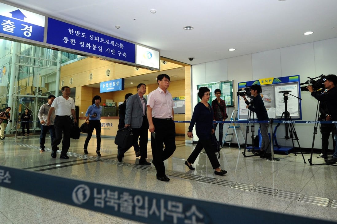 Businessmen and women walk through a border checkpoint in Paju near the Demilitarised Zone (DMZ) dividing the two Koreas as people head back to the North's Kaesong industry complex. Photo: AFP