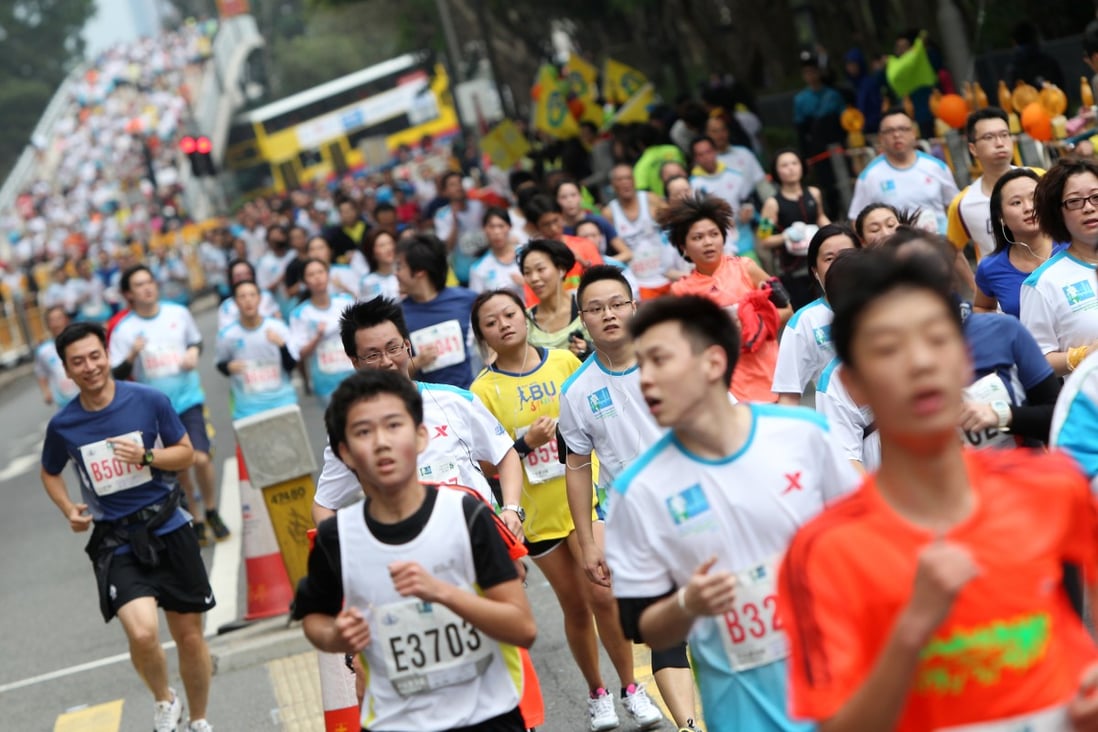 Mobile phones could be banned from next February's Standard Chartered Hong Kong Marathon after runners were accused of causing pandemonium at this year's event by stopping to take pictures of themselves. Photo: David Wong