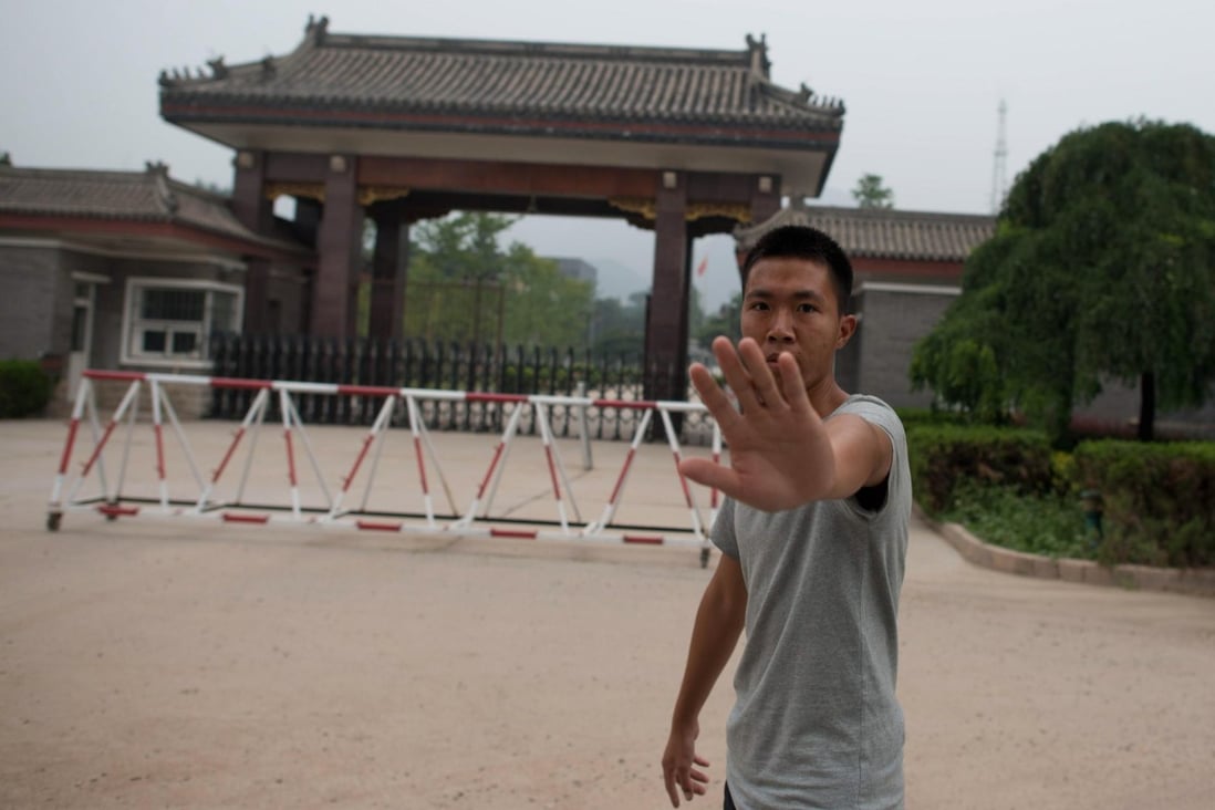 A plainclothes policeman shoos away a photographer outside Beijing's Qincheng prison. Photo: AFP