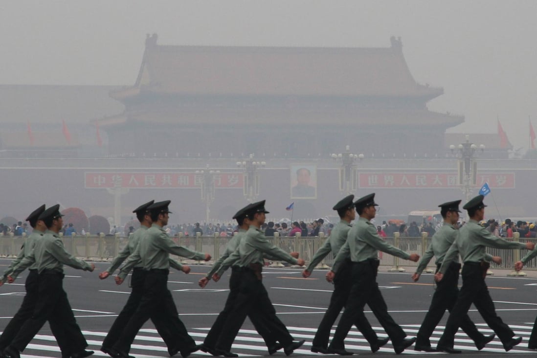 Guards march at Tiananmen Square as air pollution typical of winter affected the city. Photo: Xinhua