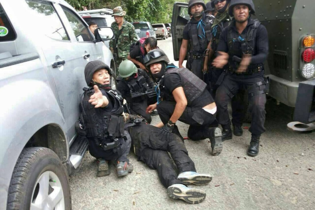 Thai police forces calling for first aid for colleague wounded during gun battle in Narathiwat province, southern Thailand. Photo: EPA