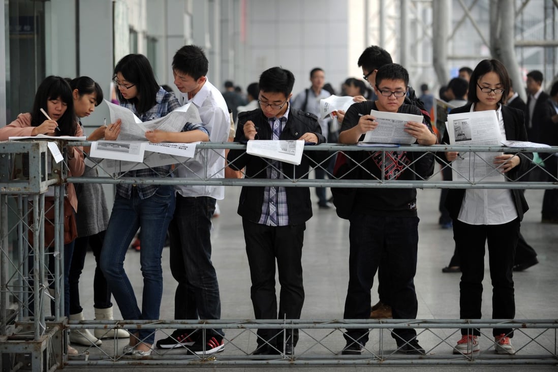 College students read information on recruiters and job vacancies at a job fair in Hangzhou. Photo: Xinhua