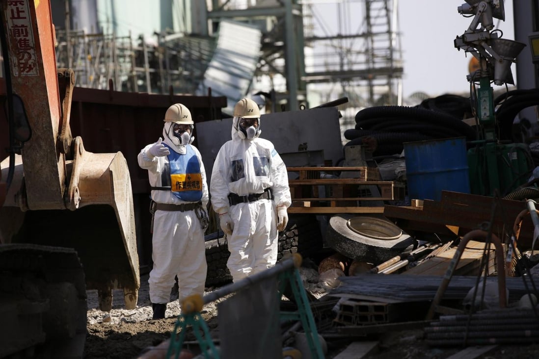 Workers wear protective suits and masks are at the No 4 reactor in Fukushima Dai-ichi. Photo: Reuters
