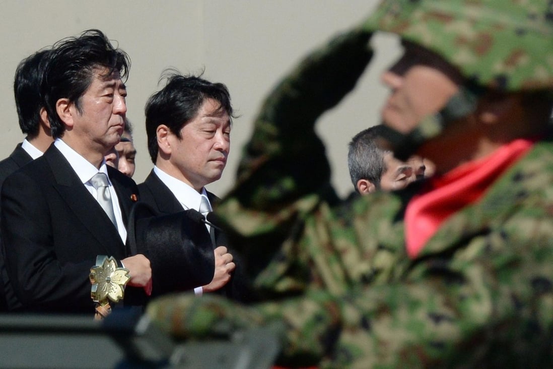 Shinzo Abe (left), inspecting troops yesterday, said the security environment surrounding Japan was becoming increasingly severe. Photo: AFP