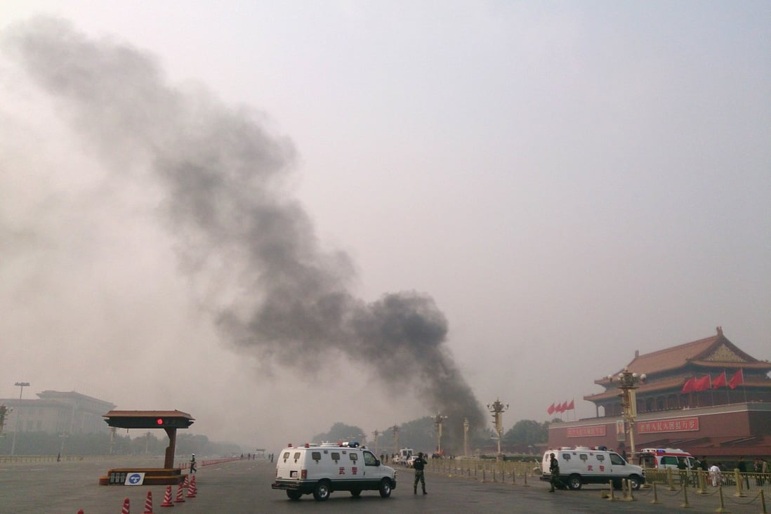 Police cars block off the roads leading into Tiananmen Square as smoke rises into the air after a vehicle crashed in front of Tiananmen Gate in Beijing on Monday. Photo: AFP