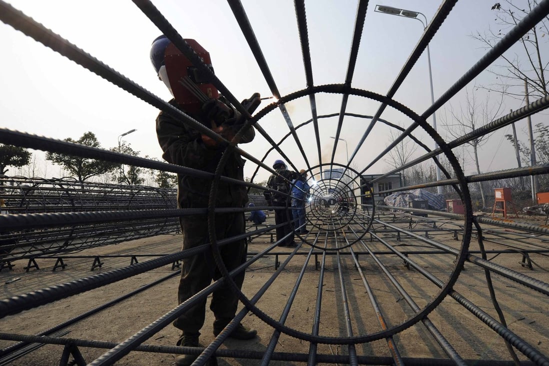 A labourer welds a steel frame at a residential construction site in China's Anhui province. Wuhu, a city in eastern Anhui province, relaxed property tightening measures in August by exempting highly educated buyers from deed tax. Photo: Reuters