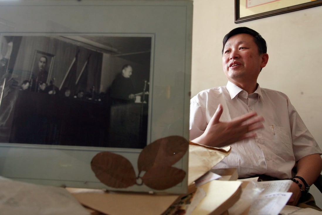 Zhang Lifan speaks behind a photograph featuring his father Zhang Naiqi (right) speaks while late Communist leader Mao Zedong (left) listens during an interview at his office in Beijing. Photo: AFP