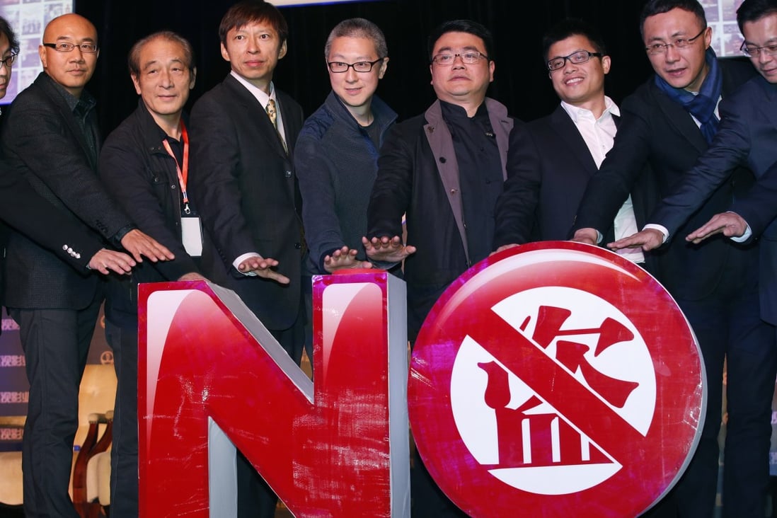 Sohu CEO Charles Zhang and Youku-Todou CEO Victor Koo (3rd and 4th L) pose with other attendants in front of an installation symbolizing action against copyright violation during their joint news conference in Beijing. Photo: Reuters