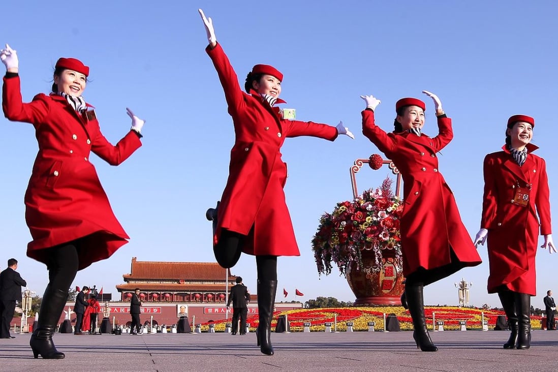 Female hotel attendants in red uniforms jump on Tiananmen Square in Beijing during the Communist Party's 18th Congress in November 2013. Photo: SCMP/Simon Song
