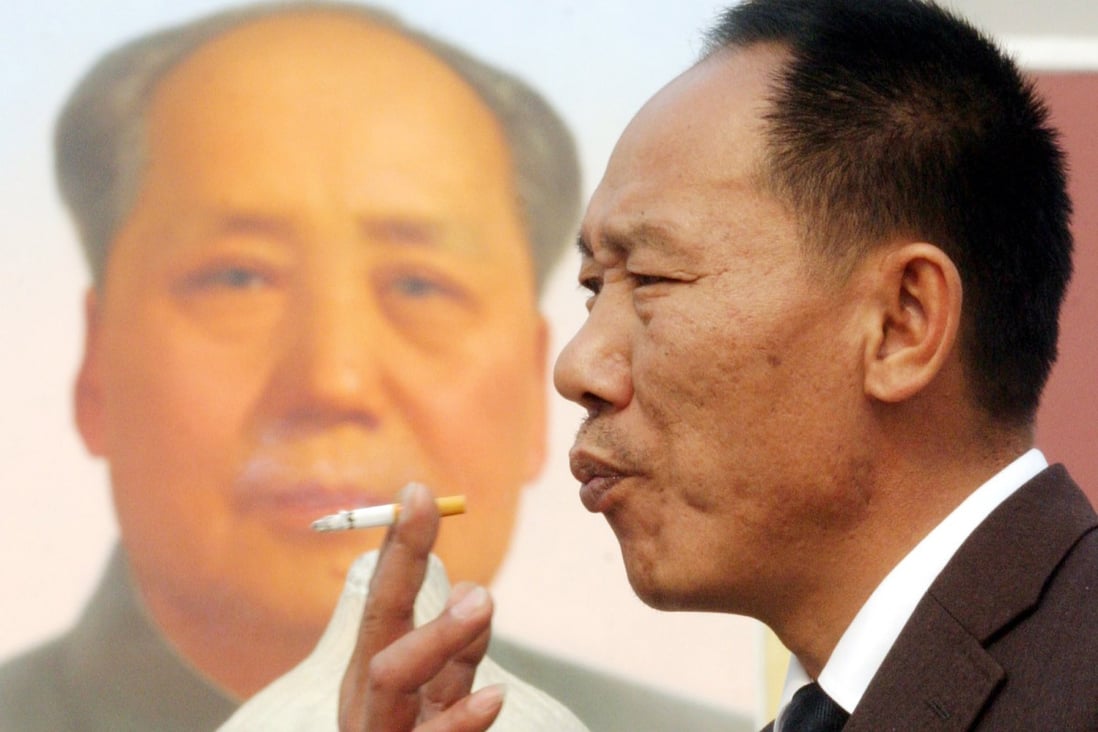 A man smokes near the portrait of the late communist leader Mao Zedong in Beijing's Tiananmen Square. Photo: AP