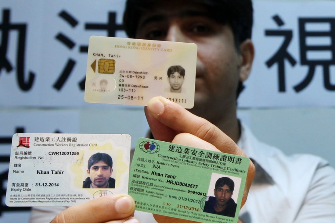 A Hong Kong born Pakistani man displays his identity cards. Ethnic minorities complain of racial profiling by police.