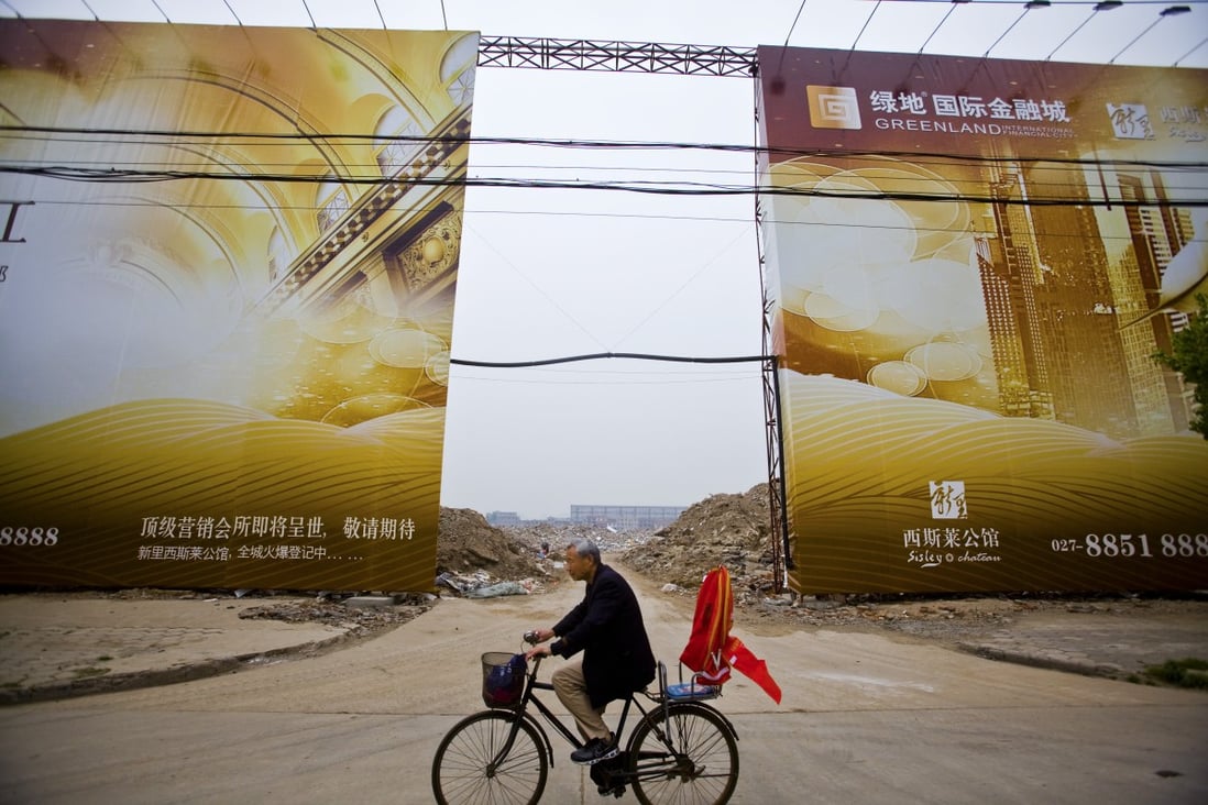 A man bikes by an empty lot to be developed by Greenland company in Wuhan. Greenland has 241 of the 250 apartments released in the first stage of Greenland Centre in Sydney. 