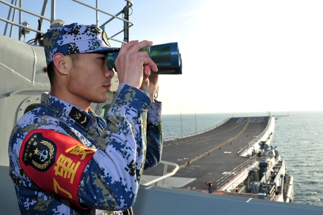 A PLA soldier on China's first aircraft carrier, Liaoning, in the South China Sea. Photo: Reuters