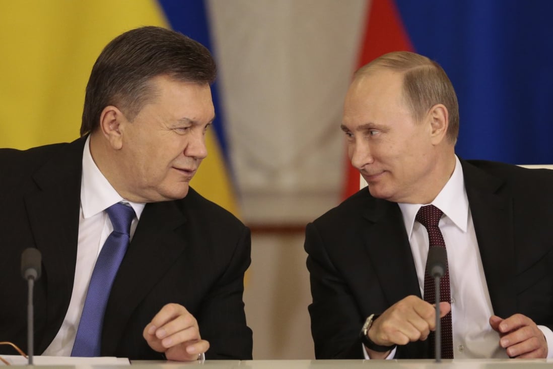 Russian President Vladimir Putin (right) and his Ukrainian counterpart Viktor Yanukovych smile after signing a bailout agreement in Moscow on Tuesday. Photo: EPA