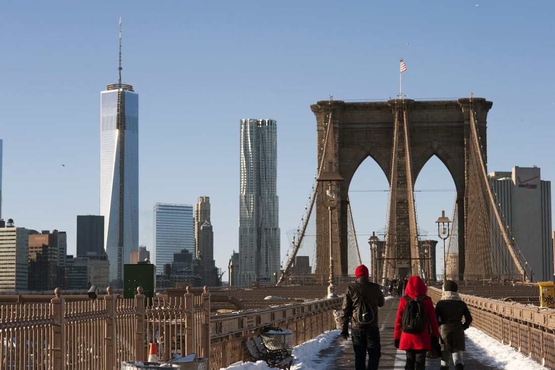 Pedestrians cross the Brooklyn Bridge to Manhattan, where the sales of condominiums and co-ops rose 27 per cent in the fourth quarter of last year. Photo: EPA