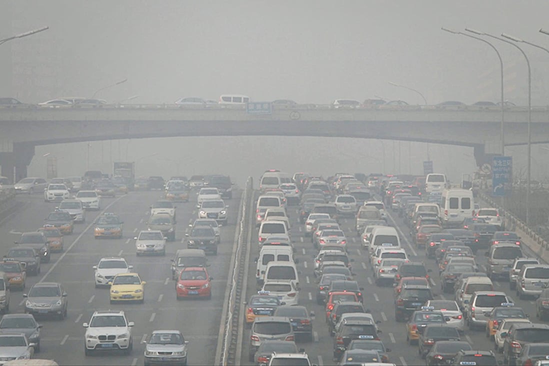 Vehicles queue in the business district of Beijing at noon yesterday, where the smog cut visibility to as low as 500 metres. Photo: Simon Song