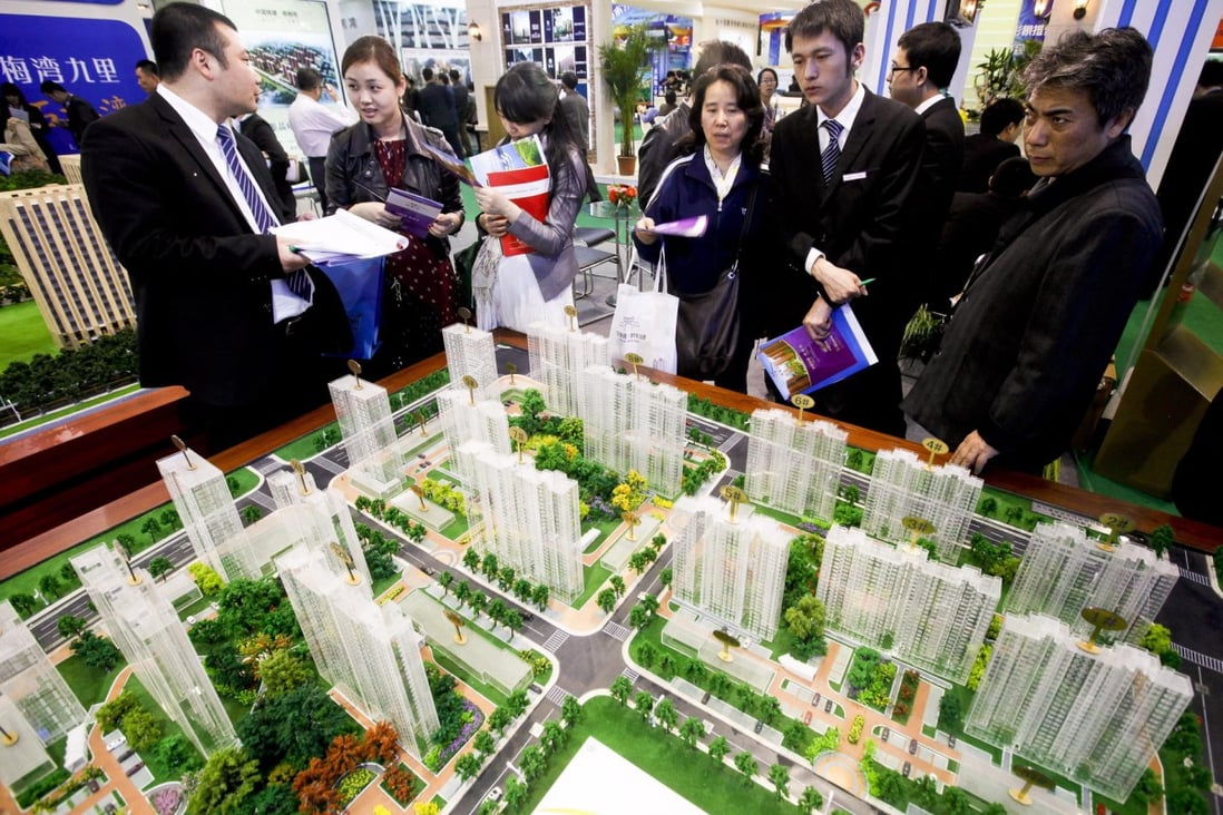 Buyers look at models of new residential developments for sale in Beijing. Home prices in Beijing and three other major cities rose more than 20 per cent in November. Photo: EPA