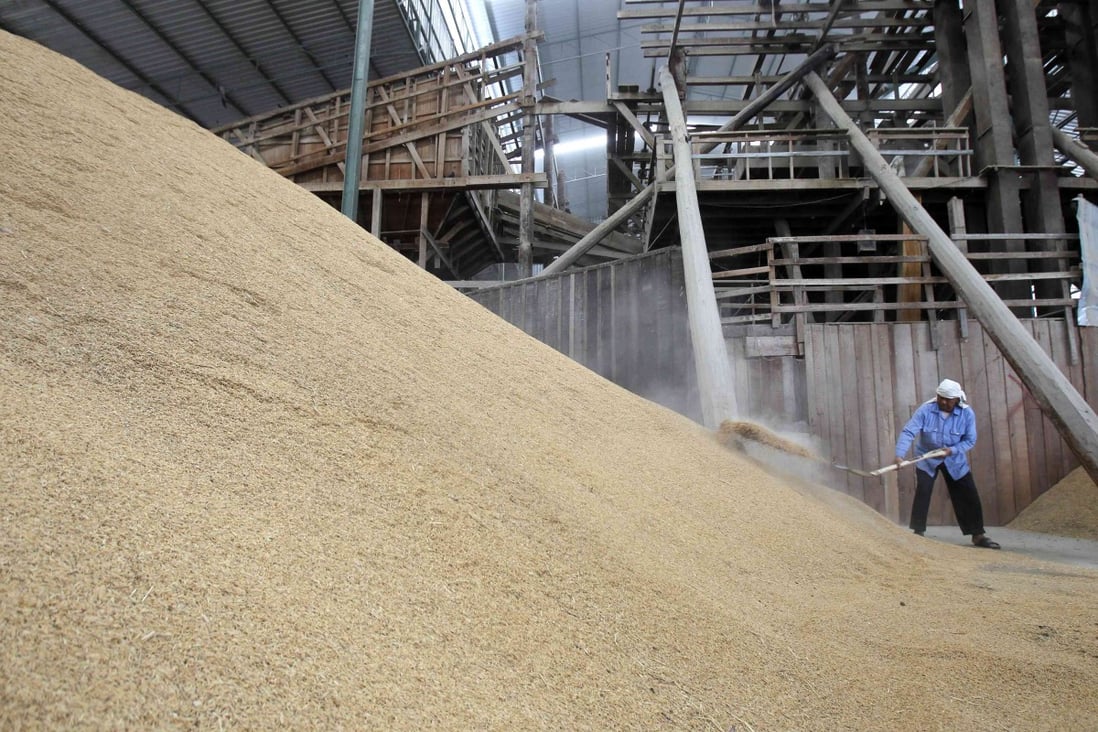 A worker shovels rice husks at a mill in Suphan Buri province. Photo: Reuters