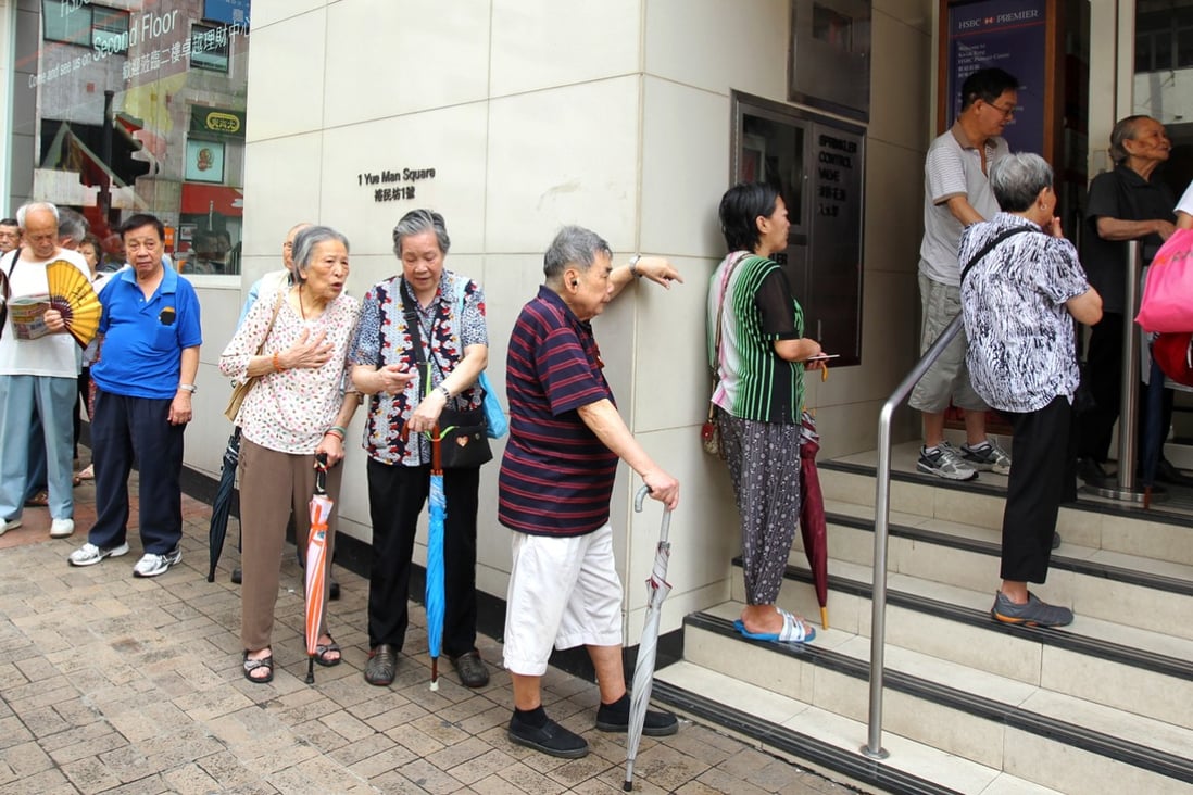 Citizens wait outside a bank for the subscription of the third issue of iBonds - which are issued by the government. The government could issue its first Islamic bond later this year. Photo: Dickson Lee
