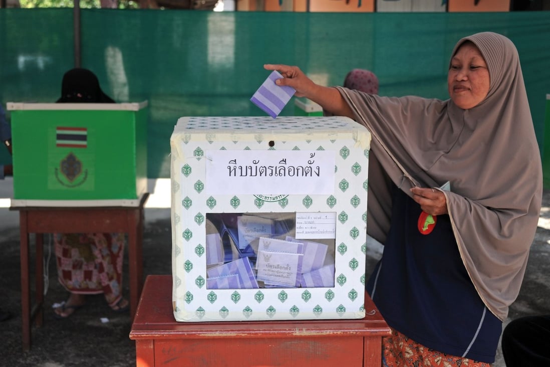 A Thai Muslim woman casts her vote in a ballot box at a polling station in Narathiwat province on Sunday. Photo: AFP