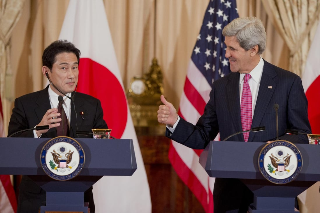 Secretary of State John Kerry checks whether Japanese Foreign Minister Fumio Kishida is receiving his message at a press conference in Washington. Photo: AP