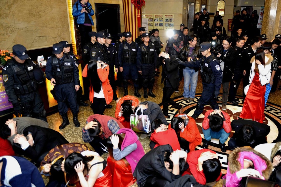 Police with suspects who were detained during a raid as part of plans to crackdown on prostitution, at a hotel in Dongguan. Photo: Reuters
