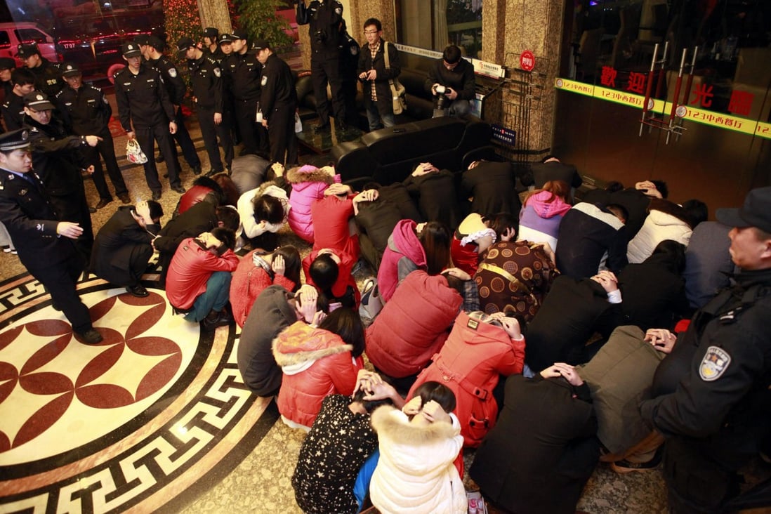 Police detain suspects during an anti-prostitution raid at a Dongguan hotel on Sunday. Photo: AP