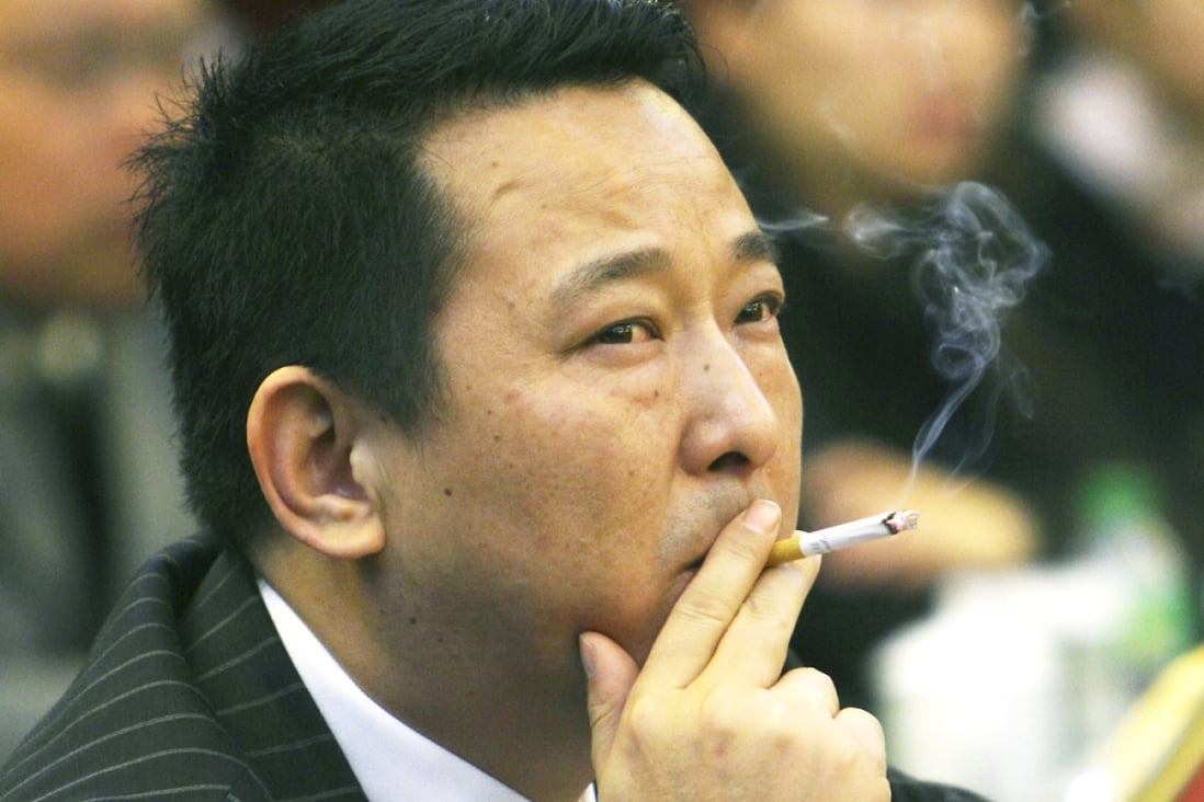 Liu Han, former chairman the Sichuan Hanlong mining group, smokes during a conference in Mianyang, Sichuan, in 2008. Photo: Reuters