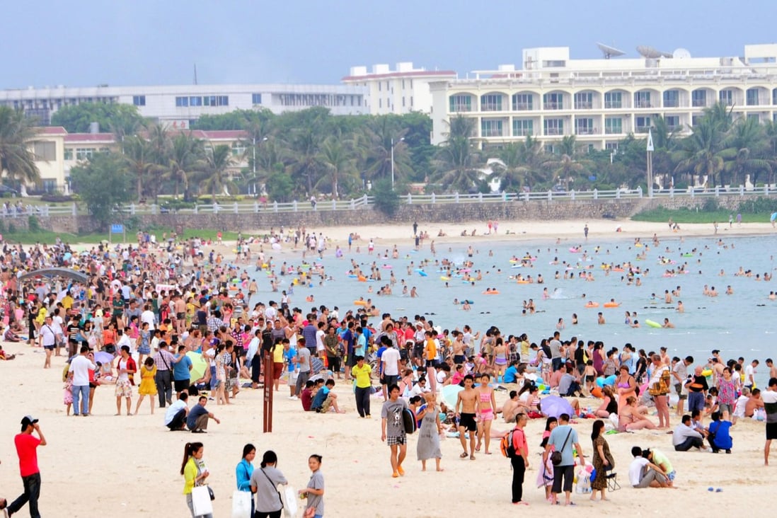 Tourists enjoy the beach at Sanya in Hainan province. The area reported just one slightly polluted day in the fourth quarter, against 189 days of pollution in Beijing. Photo: Xinhua