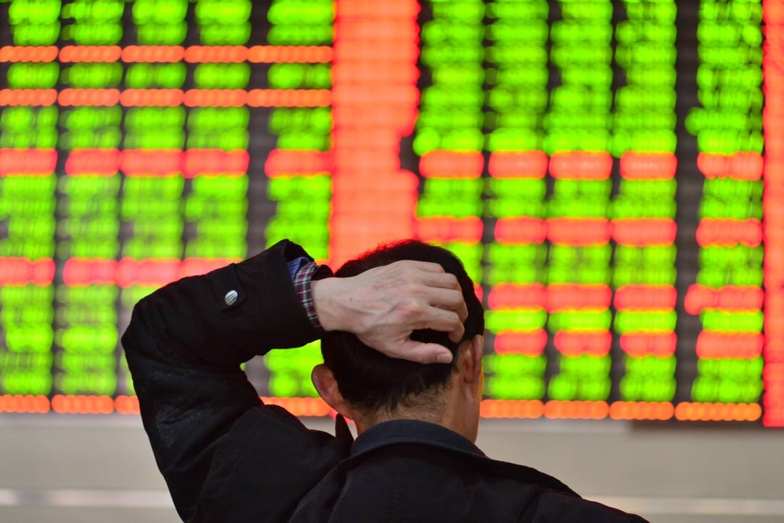 An investor scratches his head while watching stock information in a trading hall of a securities firm in Shanghai on March 10, 2014. Photo: Xinhua