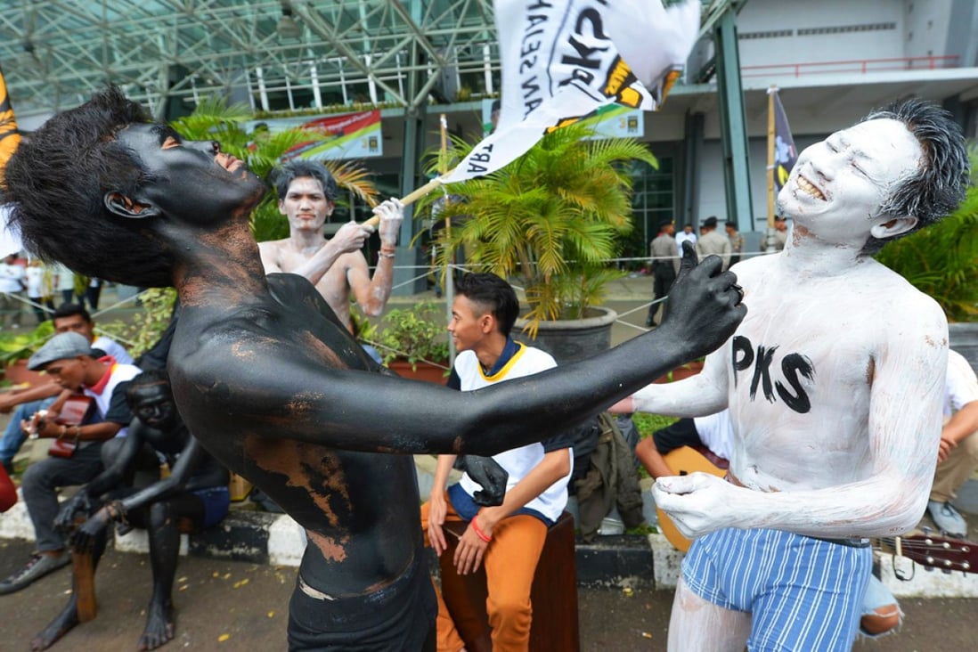 Supporters of the Justice and Welfare Party (PKS) in body paint role play at an election campaign meeting in Jakarta. Photo: AFP