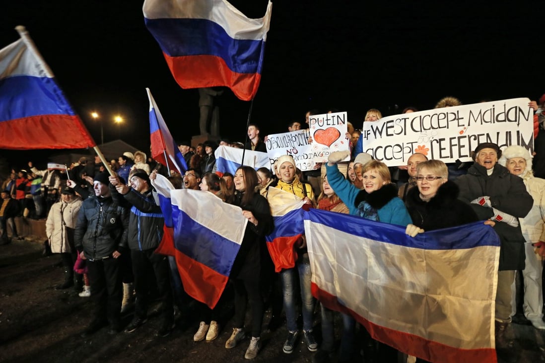 Crimean people cheer at the Lenin Square in Simferopol, Crimea. Russian President Putin signed a treaty with the leaders of Crimea and the port city of Sevastopol, making them new members of the Russian Federation. Photo: EPA