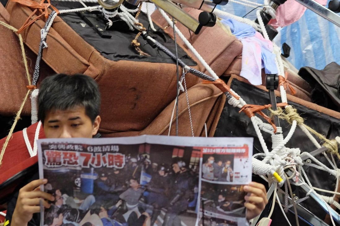 A student reads a newspaper inside parliament. Photo: AFP