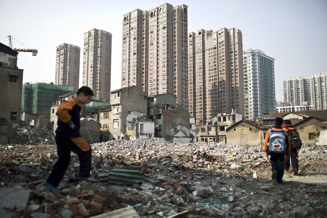 Pupils walk in an area where old residential buildings are being demolished to make room for new skyscrapers in downtown Shanghai, March 14, 2014. Photo: Reuters