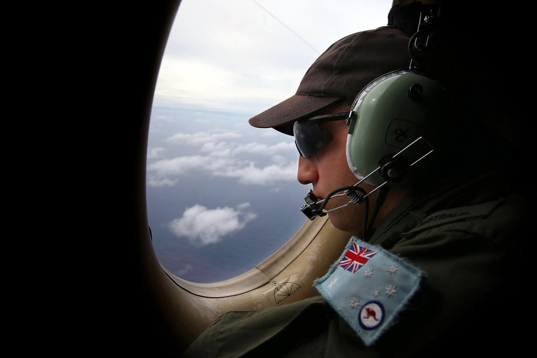An Australian officer on the lookout for debris. Photo: Reuters