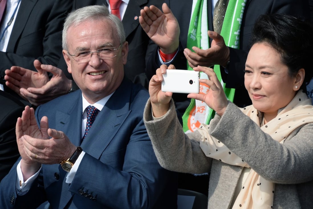 Peng Liyuan, wife of the president of the People's Republic of China, Xi Jinping, takes pictures next to Volkswagen CEO, Martin Winterkorn in Berlin, Germany on Saturday. Photo: AP
