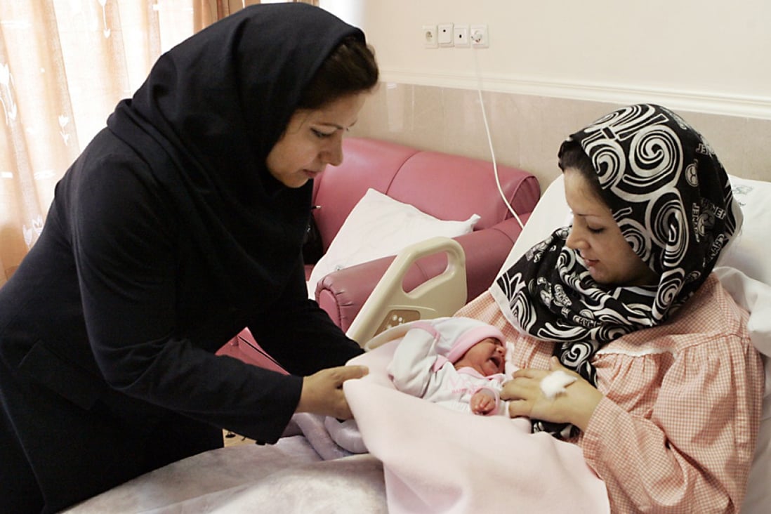 Iranian nurse gives one-day-old baby girl Setayesh to her mother at the Mehr hospital in Tehran. Photo: AP