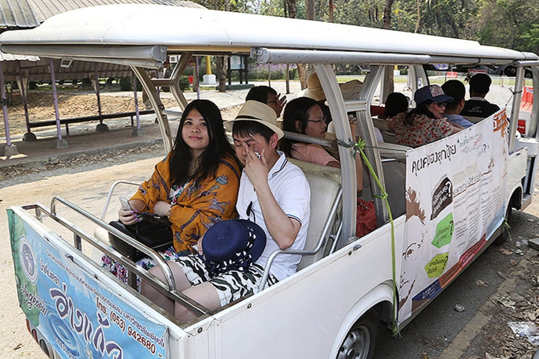 Chinese tourists ride on a cart while touring Chiang Mai University. Photo: AP