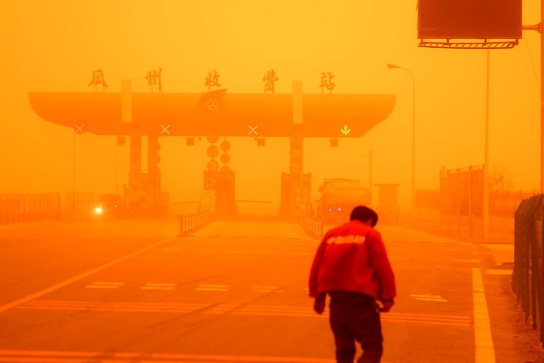 A man walks in a sandstorm at Guazhou toll station in Jiuquan,  Gansu province. Photo: Xinhua