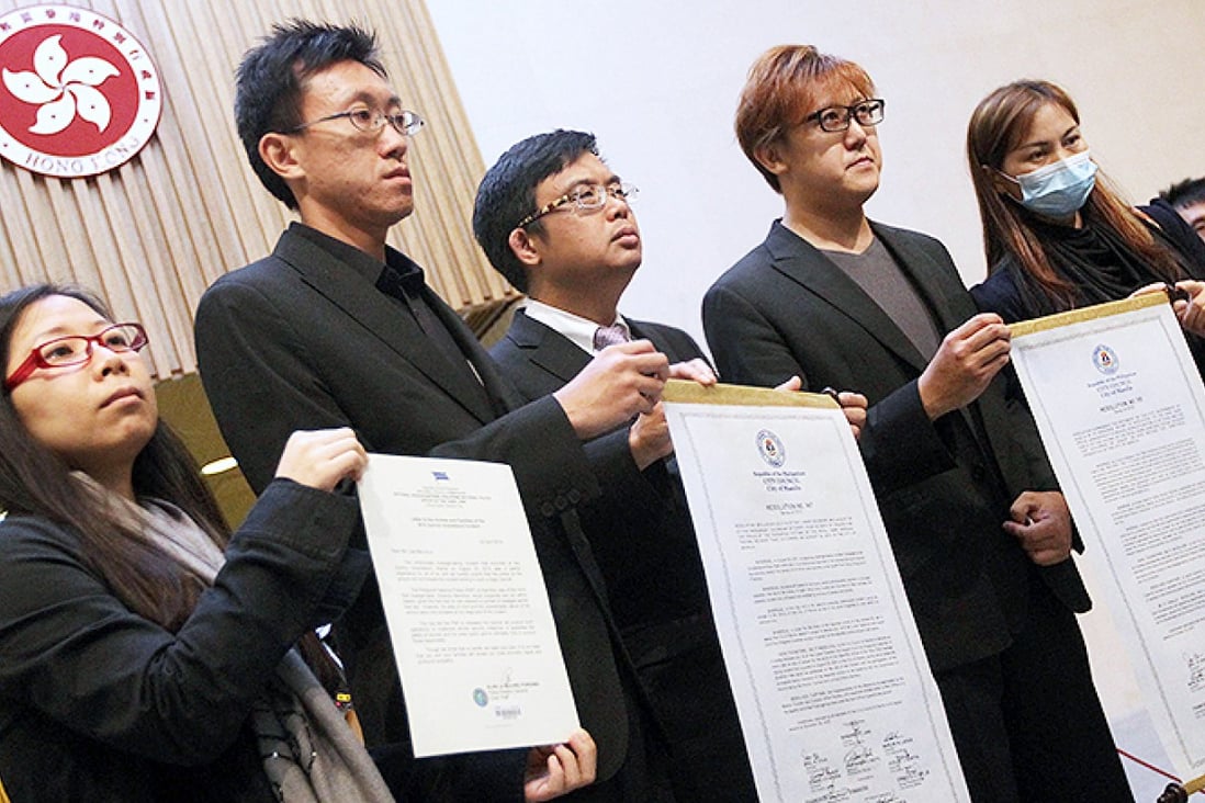 Survivor Lee Ying-chuen, deceased tour guide Masa Tse Ting-chunn's brother Tse Chi-hang, lawmaker James To Kun-sun, Tse's older brother Tse Chi-kin and survivor Yik Siu-ling with the resolutions from Manila city council and the letter from the police chief. Photo: Felix Wong