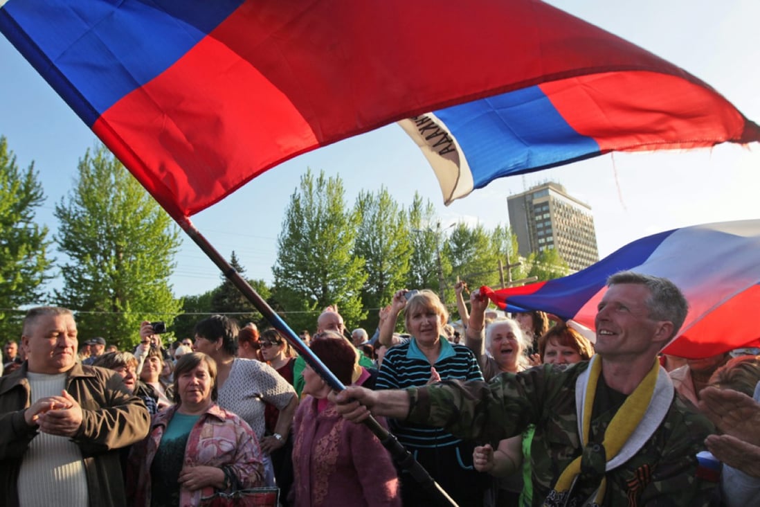 Pro-Russian supporters jubilate under a Russian flag as local residents celebrate the declaration of the 'People's Republic of Lugansk', in Lugansk, Ukraine. Photo: EPA