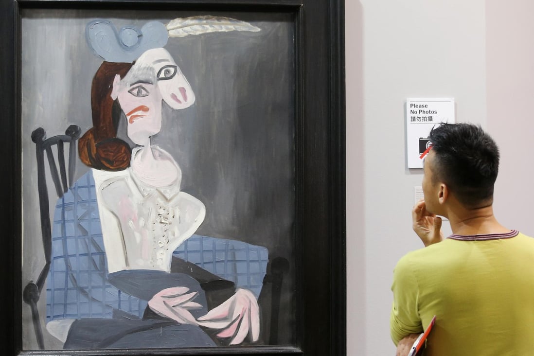 A visitor to Art Basel admires Picasso's Femme dans un Fauteuil (Woman in an Armchair) at the Convention and Exhibition Centre. Photo: K.Y. Cheng