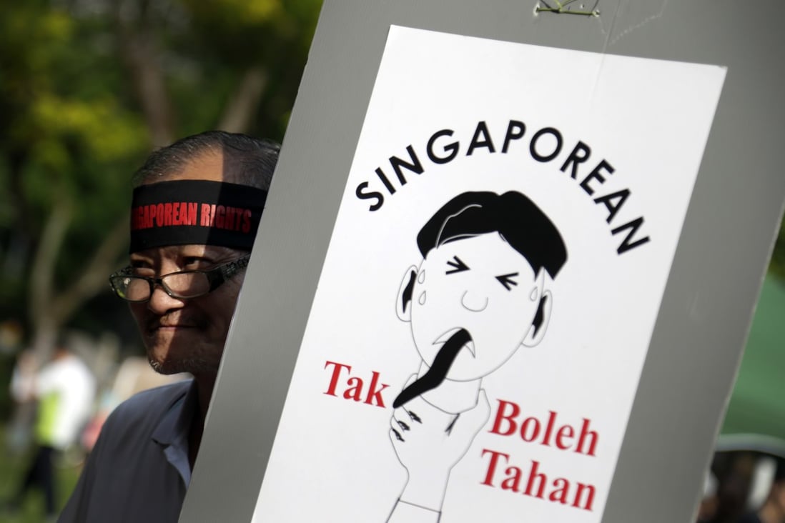 A man carries a poster which translates from the Malay language to English as "Singaporean can't take it!" as he gathers at a May Day protest in Singapore, callling for tighter curbs on the influx of foreigners. Photo: AP