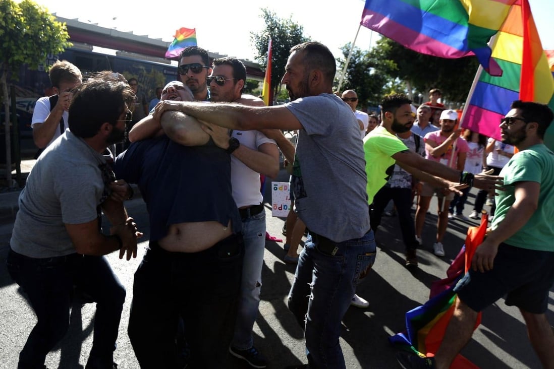 Police restrain a man who attacked gay pride marchers. Photo: AFP
