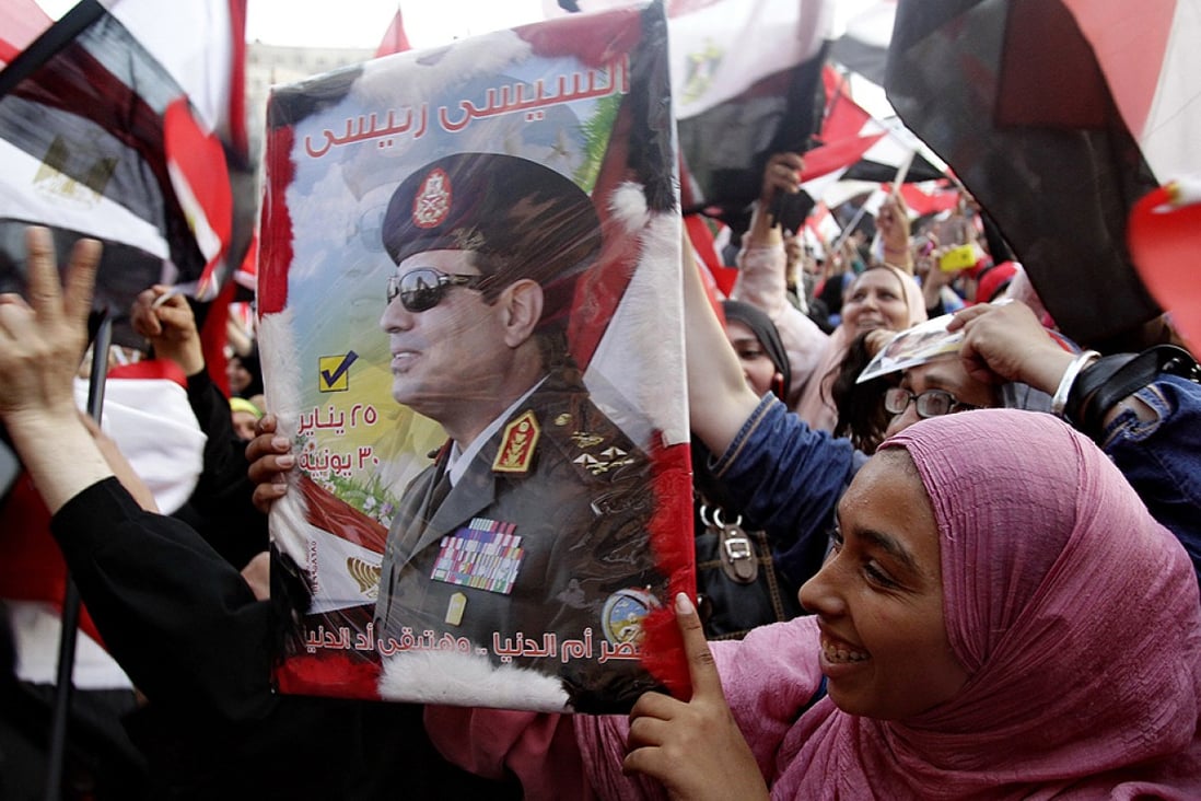  A woman holds a poster of Abdel- Fattah el-Sisi  at Tahrir Square in Cairo on Tuesday. Photo: Xinhua
