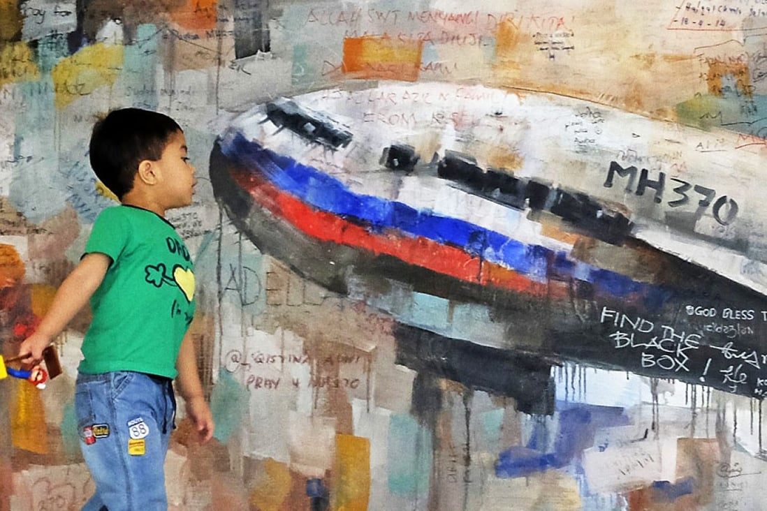 A boy looks at a painting of the missing Flight MH370 aircraft at the viewing gallery of the Kuala Lumpur International Airport. Emirates chief Tim Clark has questioned why fighter jets did not intercept the flight. Photo: EPA